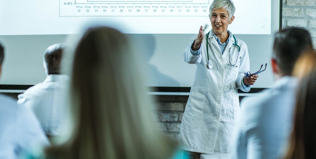 senior-female-lecturer-assists-medical-students-during-class