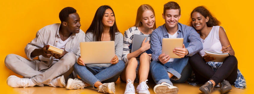 A diverse group of college students sit next to each other holding laptops, tablets, and notebooks.